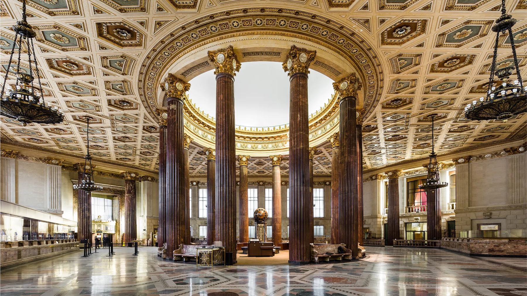 The domed banking hall of the Dime Savings Bank, ringed by polished columns under a coffered ceiling.
